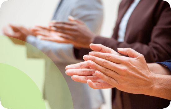 Diverse group of business professionals clapping hands, celebrating success while exploring spiritual dimensions of well-being.